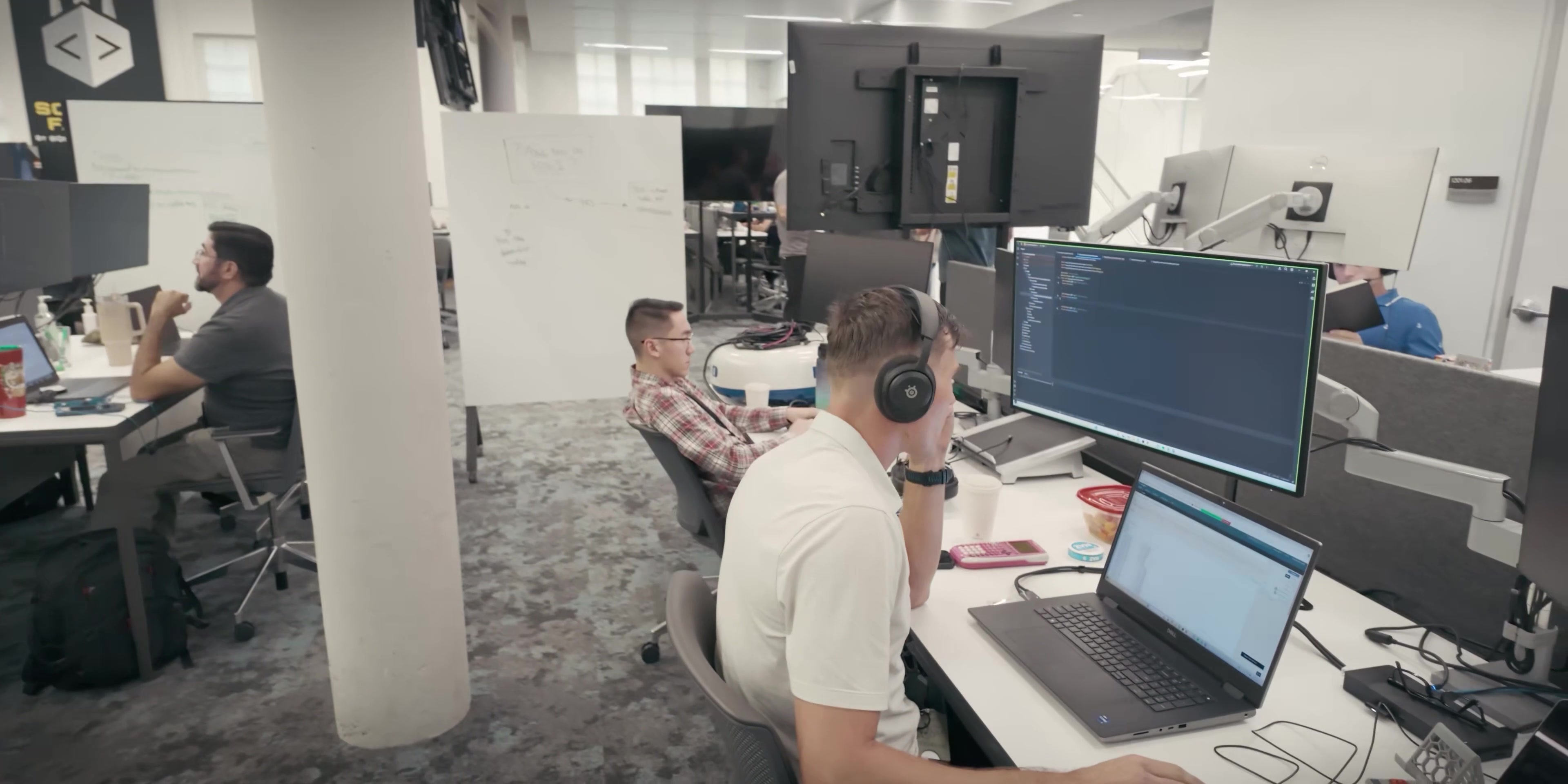 Developers work across a shared software-development office.
