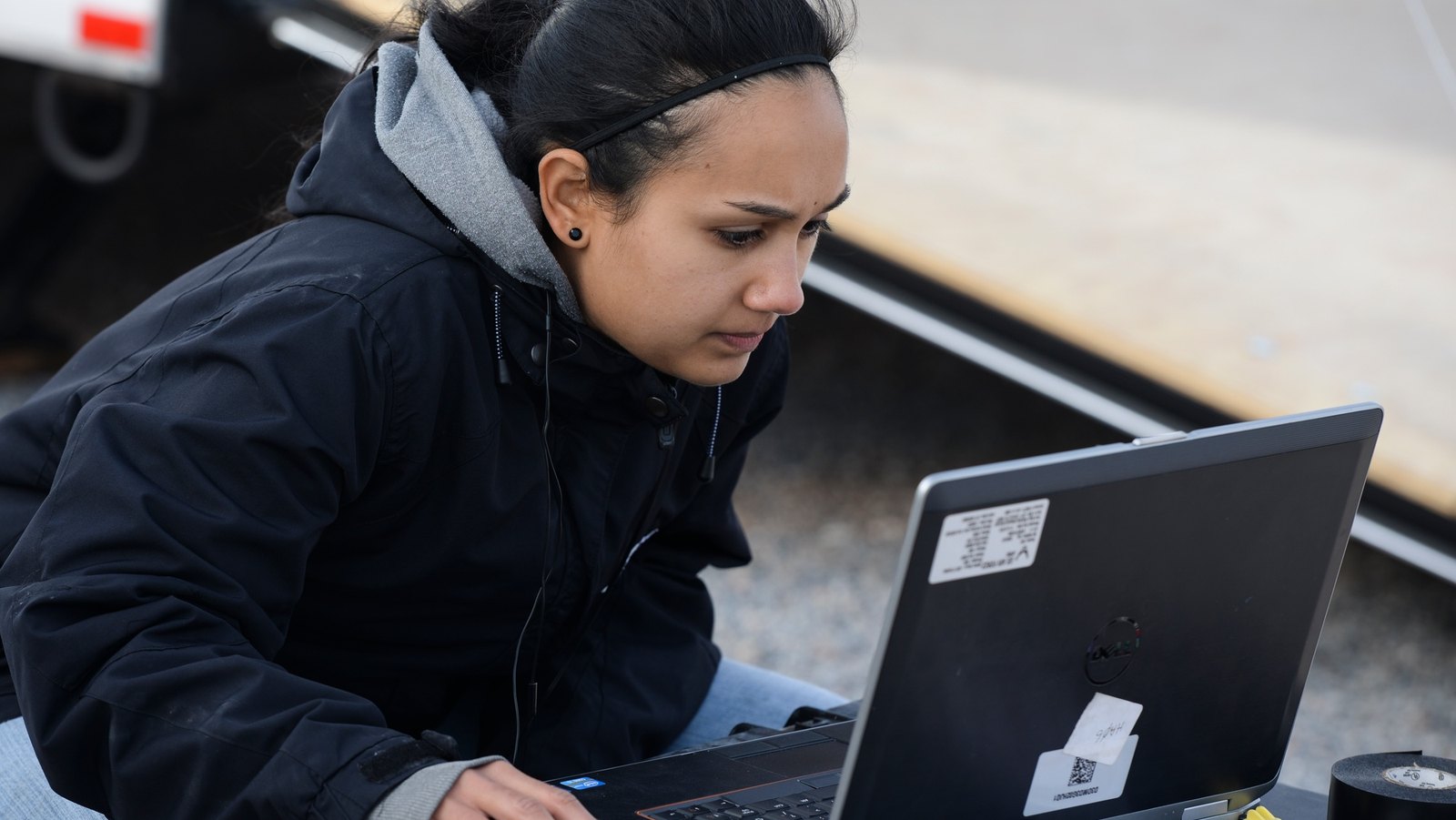 A technology team member checks a laptop during an outdoor systems test.